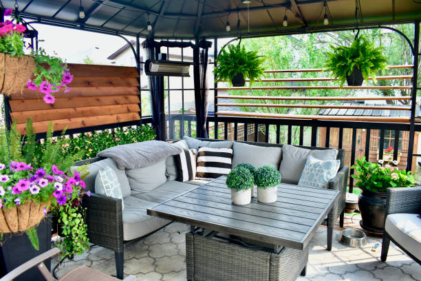 Outdoor backyard sheltered patio seating with a tropical Caribbean feel for summer relaxation Beautiful seasonal outdoor living room with lush greenery and flowers for spring and summer staycation relaxing. sheltering photos stock pictures, royalty-free photos & images