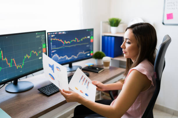 Attractive woman doing a work presentation Business analyst looking at a graph chart while working from home as a freelance. Professional young woman buying stocks investors stock pictures, royalty-free photos & images