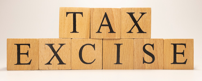 The name Excise tax was created from wooden letter cubes. Economics and finance. close up.