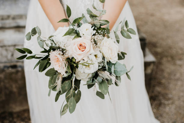 花のヴィンテージスタイルの束を保持している花嫁のクローズアップ - 結婚式 ストックフォトと画像