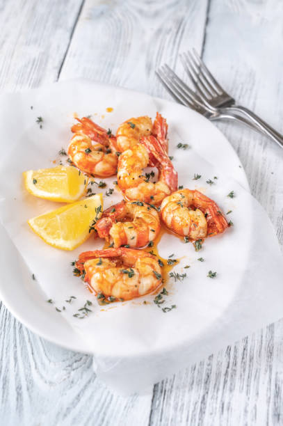 istock Shrimps with thyme and lemon wedges 1332379035