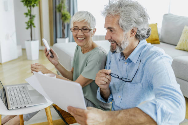 istock Happy mature couple using laptop while planning their home budget 1332379665
