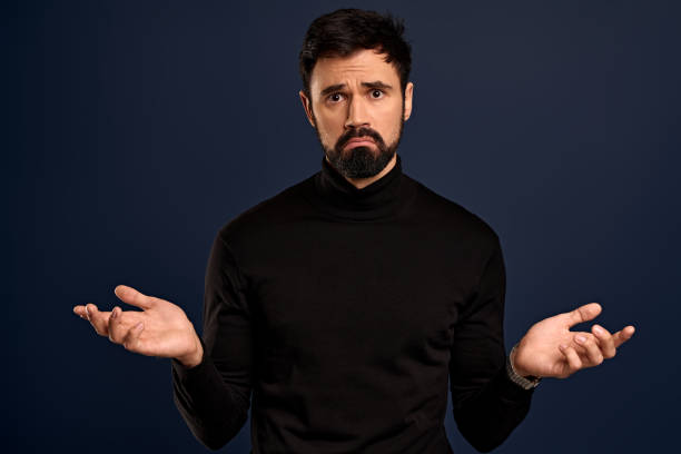 istock Guy avoids answers as feeling pressured and indecisive, dodging questions. Perplexed male coworker, shrugging tilt head and spread hands sideways in dont know, clueless gesture, smile awkward 1332384294