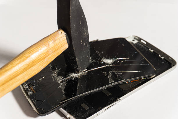 istock Hit the smartphone screen with a hammer. Cracked phone screen. Broken phone on a white background. Fight against telephone addiction. 1332384427