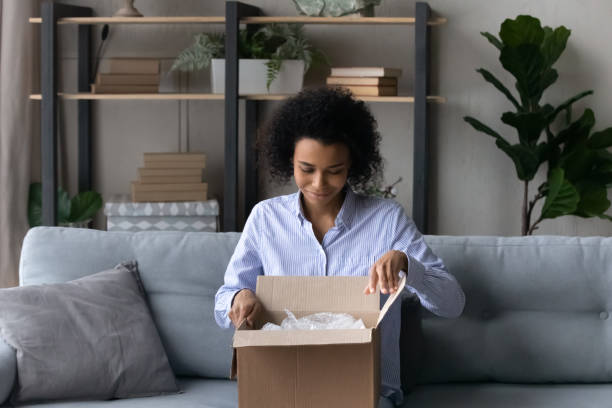 istock Happy African American woman unpack box with internet order 1332387115