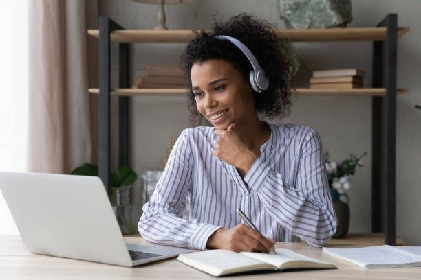 istock Smiling ethnic female study online on laptop 1332387169