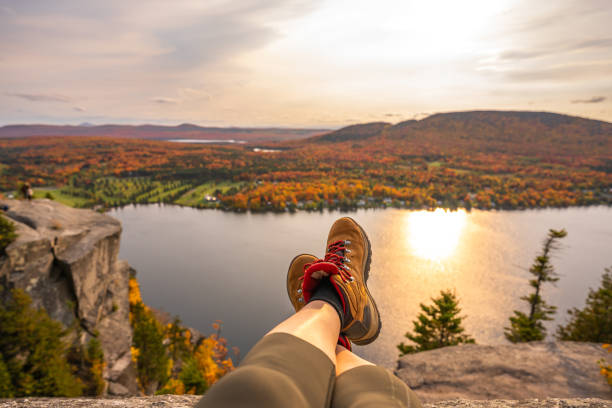 Woman looking at lake and forest during autumn. POV photo of a woman looking at Lyster lake with forest of Quebec and Vermont seen from the Mount Pinacle in Coaticook during autumn. new england usa photos stock pictures, royalty-free photos & images