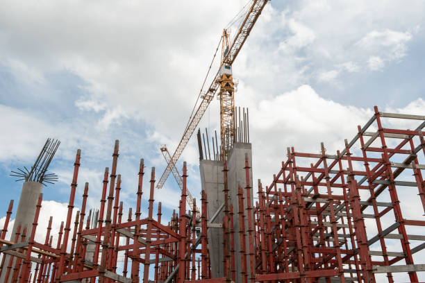 canteiro de obras o início da construção de um arranha-céu de concreto armado. andaimes e guindastes. - progress technology new manufacturing - fotografias e filmes do acervo