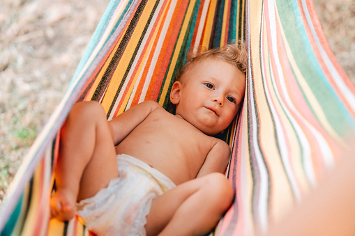 Baby boy playing with his mother at hammock