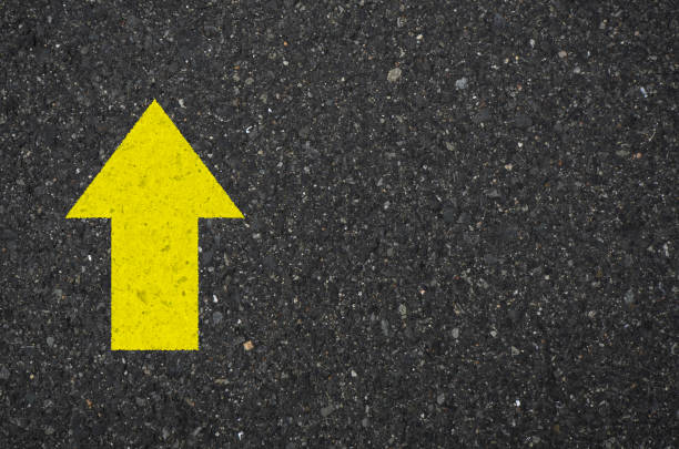 istock Asphalt with a yellow up arrow sign 1332397836