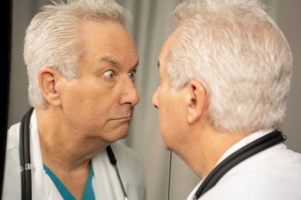 istock Doctor making funny faces in the mirror 1332399417