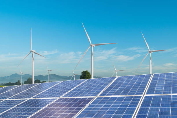 istock Solar panels with wind turbines generating electricity over blue sky background. 1332400480