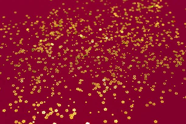 istock Gold glitter stars on a dark red background 1332401903