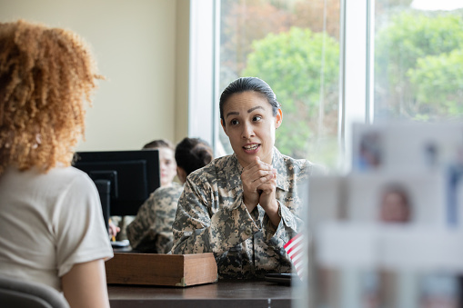 Female military recruiter explaining options to perspective female soldier.