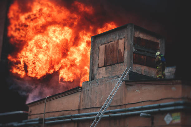 istock Firefighters put out large massive fire blaze, group of fire men in uniform during fire fighting operation in the city streets, firefighters with the fire engine truck fighting vehicle 1332404569