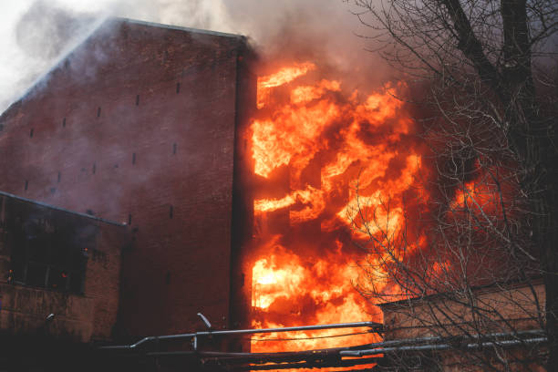 istock Massive large blaze fire in the city, brick factory building on fire, hell major fire explosion flame blast,  with firefighters team firemen on duty, arson, burning house damage destruction 1332404657