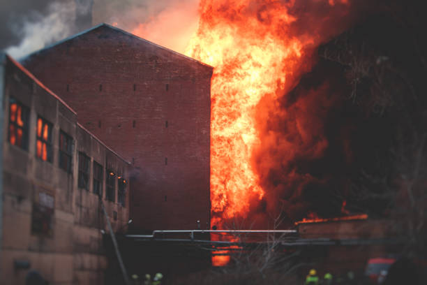 istock Massive large blaze fire in the city, brick factory building on fire, hell major fire explosion flame blast,  with firefighters team firemen on duty, arson, burning house damage destruction 1332404665