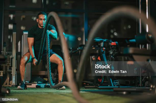 Asian Indian Mid Adult Macho Man Practicing Battle Rope In Gym Stock Photo - Download Image Now