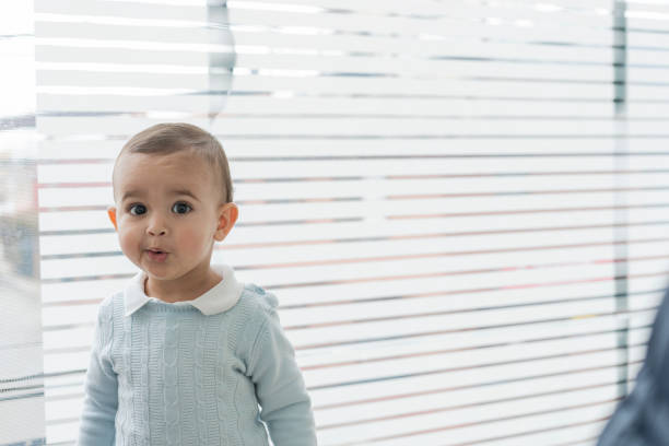 Beautiful 1 to 2 year old boy looking at the camera in a portrait while visiting his pediatrician in the office