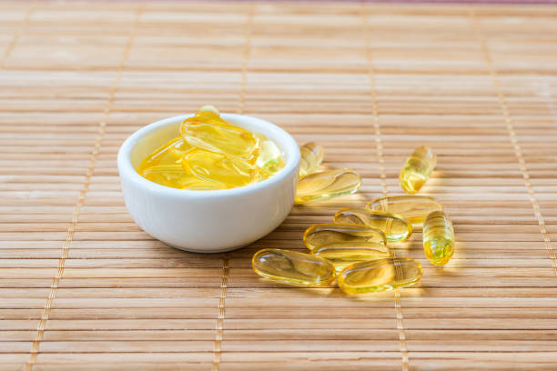 kabeljau leberöl omega 3 gel kapseln in der schüssel - vitamin d capsule softness gel effect stock-fotos und bilder
