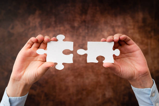 istock Hands Holding Two Pieces Of Jigsaw Puzzle.Cooperation For Finding And Resolving Missing Ideas At Work.Businessman Find Strategy For Resolving, Connecting Thoughts 1332410739