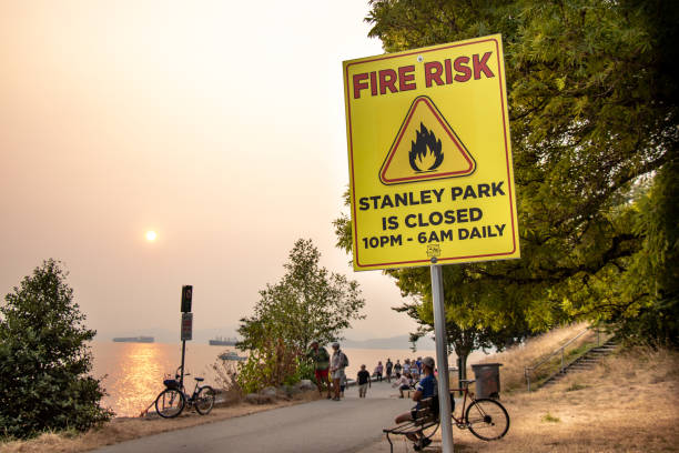 View of sign Fire Risk, Stanley Park is Closed on Second Beach. Smokey Sky over Vancouver from wildfires stock photo