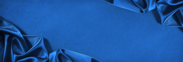 istock Beautiful blue silk satin background. Wavy soft folds. Elegant fabric background with copy space for design. Web banner. 1332422861