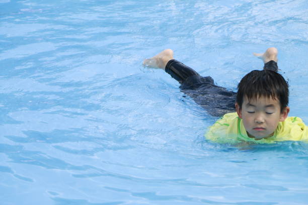 istock Little boy in swimming pool 1332423013