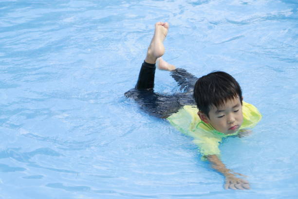 istock Little boy in swimming pool 1332423068