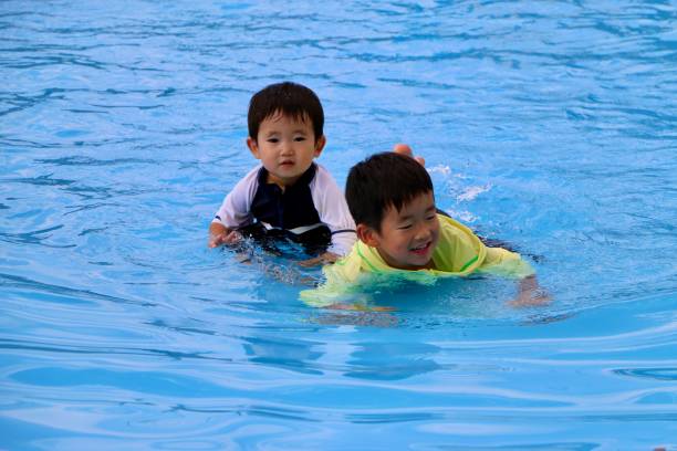 istock Little boys in swimming pool 1332424053