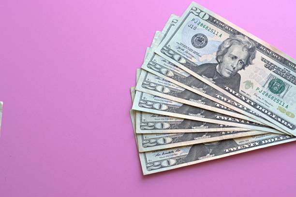 istock US dollars laid out on a pink background 1332426780