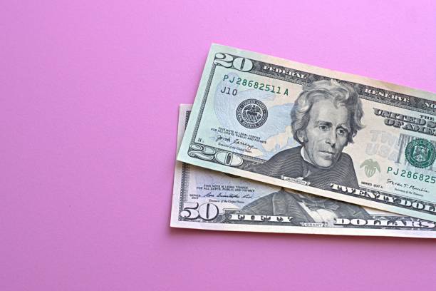 istock US dollars laid out on a pink background 1332426781