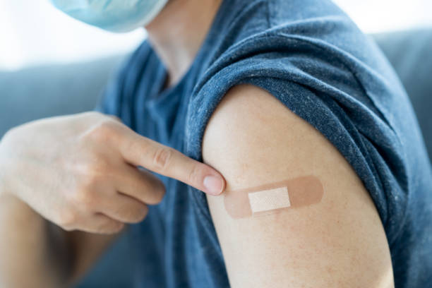 istock Man pointing at vaccine injection point. 1332429866