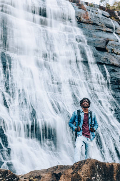 istock Afro man in front of a high waterfall 1332431000