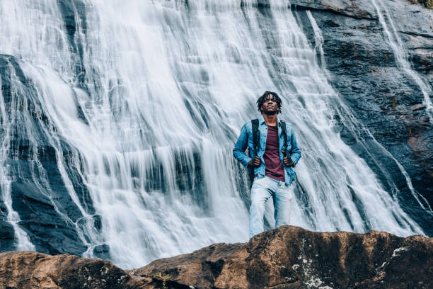 istock Afro man in front of a high waterfall 1332431005