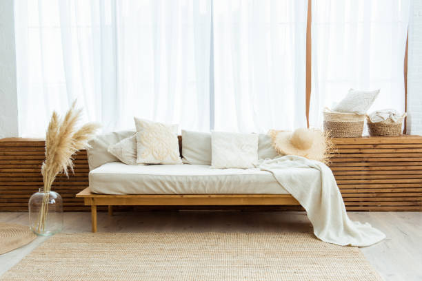 istock Cozy small multifunctional room interior in Scandinavian style, natural light and minimalistic design, natural decor, eco friendly wooden sofa with large window 1332432117