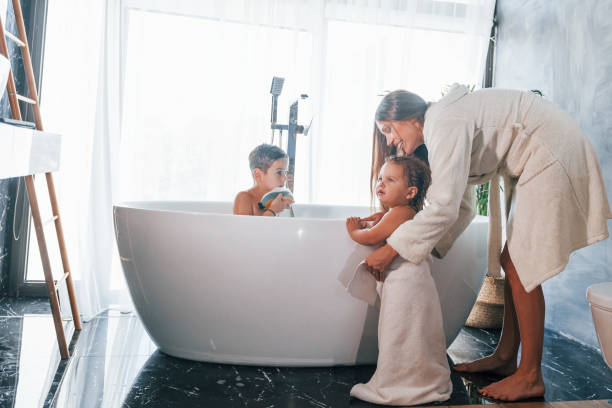 istock After washing. Young mother helps her son and daughter 1332441002