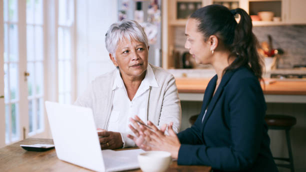 scatto di una donna anziana che usa un laptop durante un incontro con un consulente a casa - 401k retirement planning financial advisor foto e immagini stock