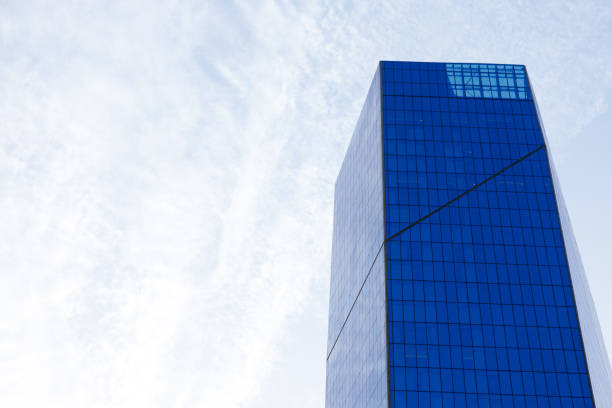 istock Glass skyscraper building with cloudy blue sky background 1332442901