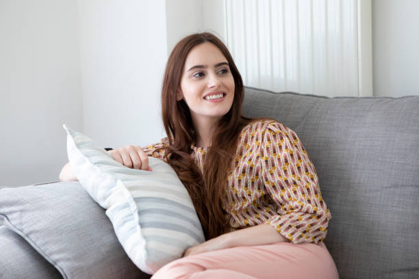 istock One young woman relaxing on a sofa and looking to the side 1332443105