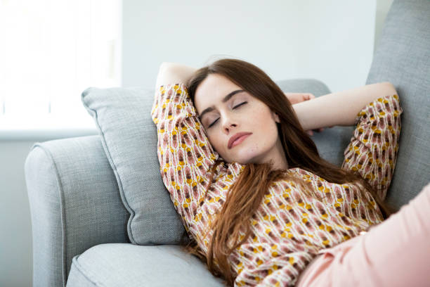 istock One young woman relaxing on a sofa, lying on her back with her eyes closed 1332443146
