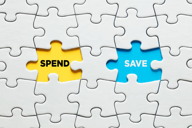 istock Missing puzzle pieces with the words spend versus save. Decision or dilemma between financial spending or saving options 1332443916