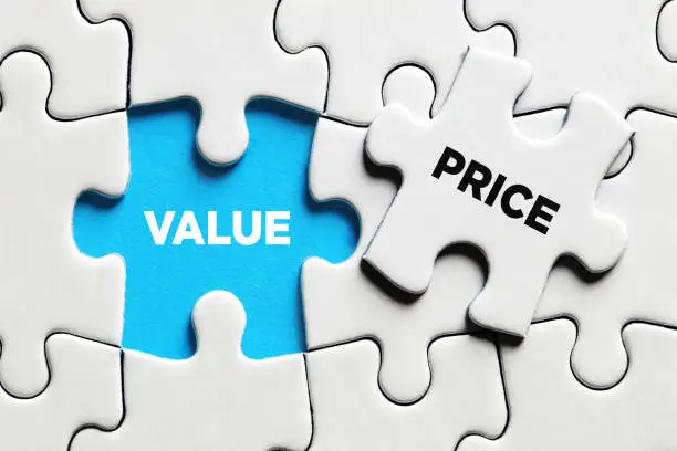 Photo of The word value revealed with a missing puzzle piece with the word text. Price and value balance