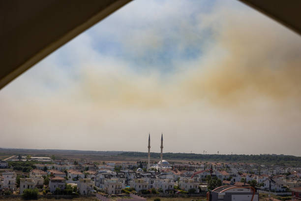 Smoke from forest fires during extreme hot temperatures over village of Belek in Turkey Panorama taken from high rise building towards outskirts of small Turkish city with visible minarets of the mosque. belek town stock pictures, royalty-free photos & images