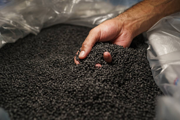 istock Close up of male hand holding plastic polymer granules 1332446320