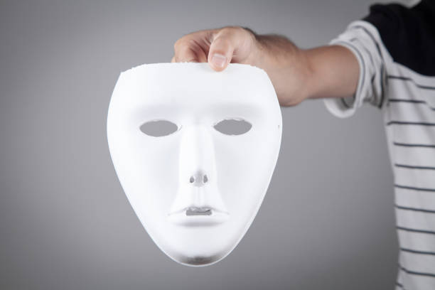 istock Man holding white mask. Fake, anonymous 1332447712