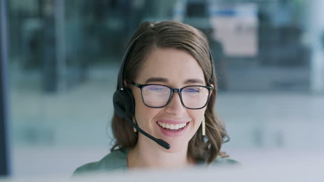 4k video footage of a young woman using a headset and computer in a modern office