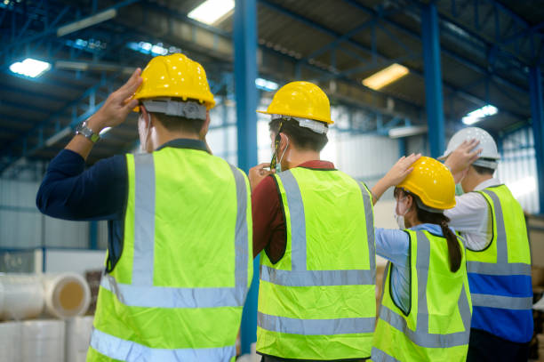 istock Engineer people are putting a protective helmet on  head in warehouse 1332454627