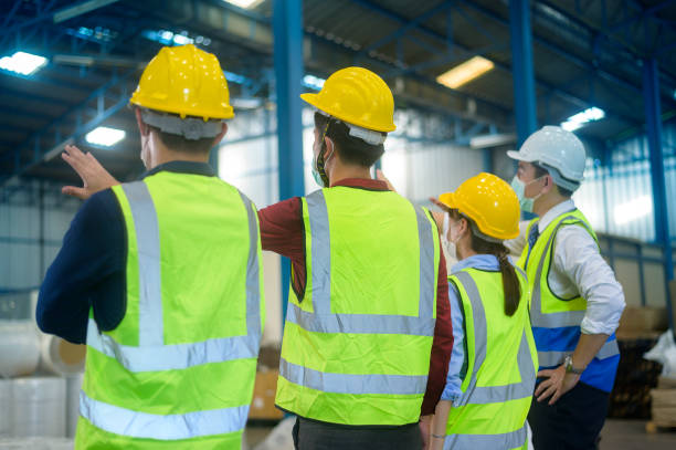 istock Engineer people are putting a protective helmet on  head in warehouse 1332454726
