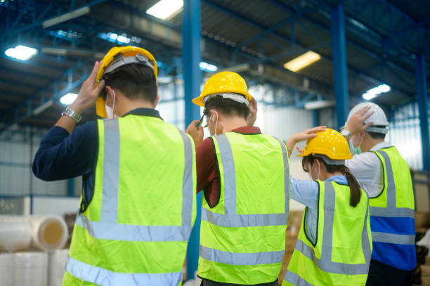 istock Engineer people are putting a protective helmet on  head in warehouse 1332454746